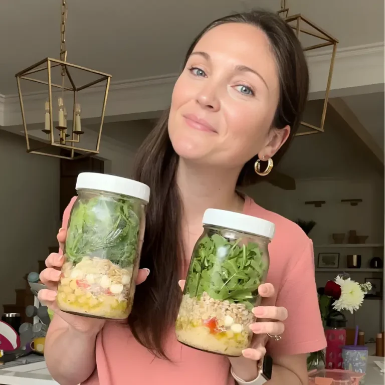 Aurora Prado holding two salad jars in her kitchen